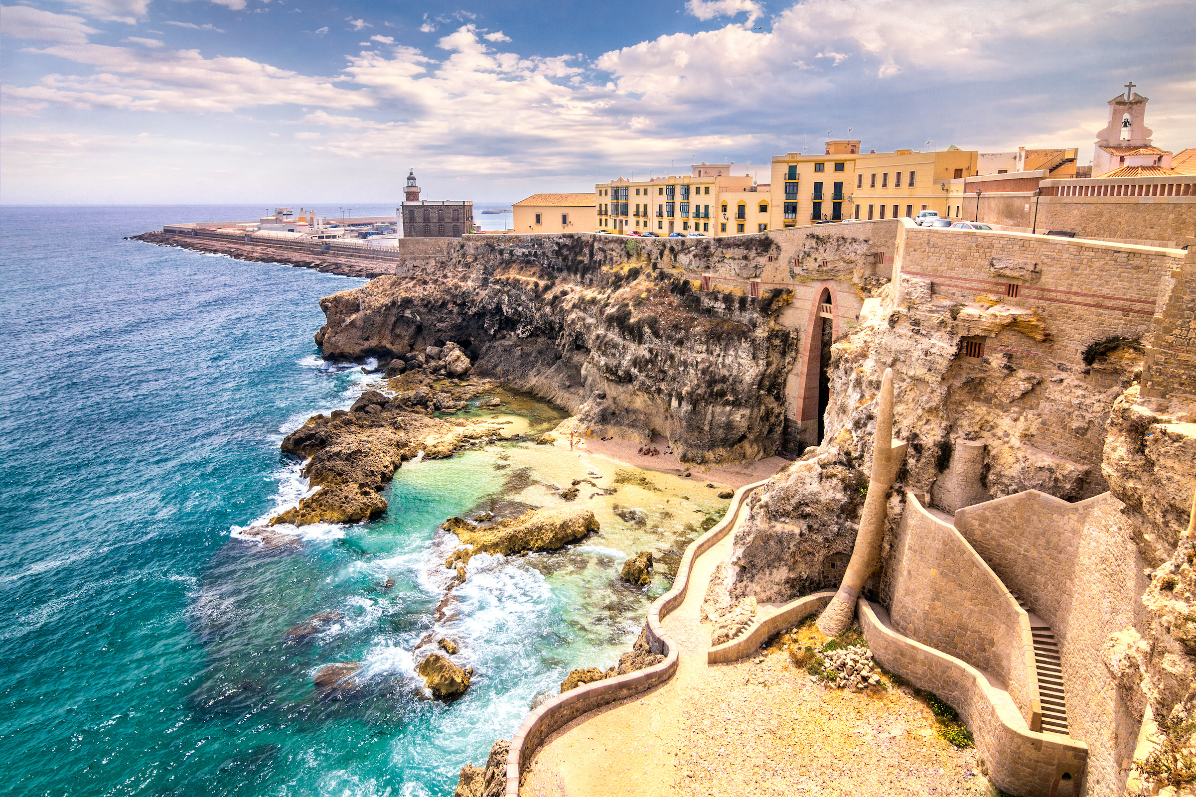 Hafen von Melilla mit Leuchtturm und historischer Stadtmauer